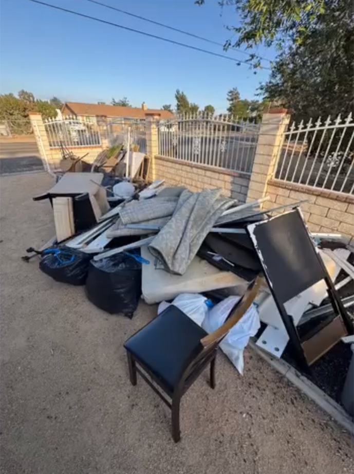 Large outdoor pile of furniture, mattresses and bagged junk before removal